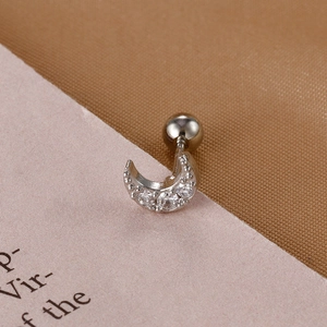 Macro detail of silver crescent moon cartilage stud earring with cubic zirconia inlay