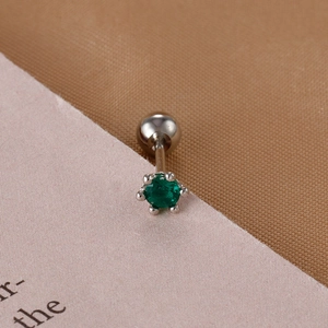 Close-up of green zircon stud earring with silver screw ball back for cartilage piercing