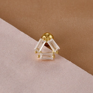 Macro shot of gold surgical steel screw back earring with three baguette cut zircons