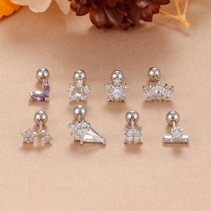 Set mit 8 Edelstahl-Ohrknorpelpiercings mit Zirkonia auf goldenem Satinstoff-Hintergrund