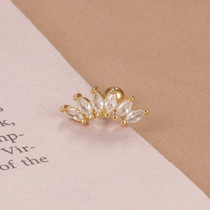 Macro shot of crown-shaped stud earring with marquise-cut zircon stones in gold plating