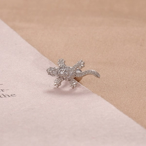 Macro detail of silver lizard stud earring with micro-paved white cubic zirconia stones