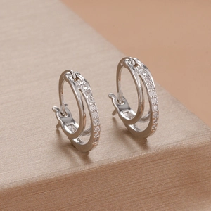 Detailed macro view of silver double hoop earrings with pave-set zircon stones