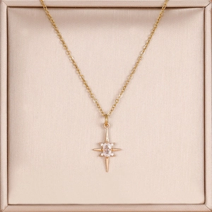Dettaglio di un ciondolo a stella in oro 14K con zirconi incastonati in un portagioie