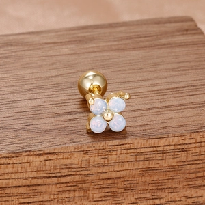 Gros plan sur boucle d'oreille fleur en opale bleue et or avec fermoir à vis