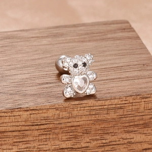 Gros plan détaillé d'un clou d'oreille ours en argent avec zircons et pierre en forme de cœur