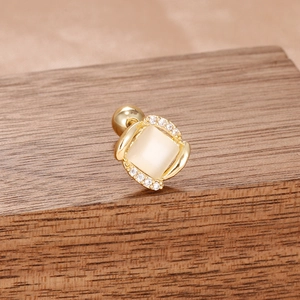 Détail d'une boucle d'oreille carrée en opale dorée avec micro-incrustation de zircons