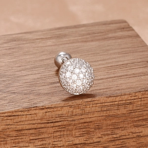 Vue macro d'une boucle d'oreille géométrique en argent avec zircons étincelants pavés