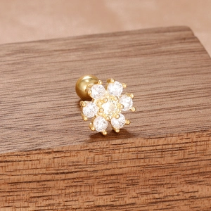 Vue détaillée d'une boucle d'oreille fleur dorée avec sept zircons et fermoir à vis