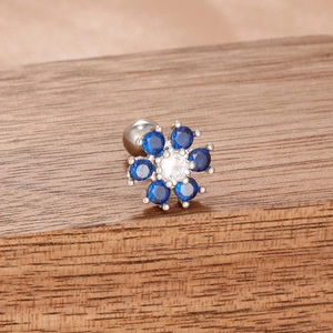Gros plan de boucles d'oreilles fleur en gemmes bleues avec métal argenté et fermoir