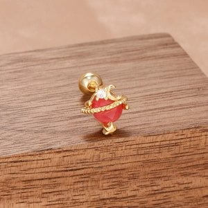Clou d'oreille Saturne doré avec pierre rouge et oxydes de zirconium sur bois
