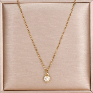 Makroaufnahme einer goldenen Herzkette mit klarem Zirkonia in einer Schmuck-Geschenkbox