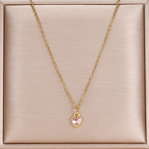 Detail einer goldenen Edelstahlkette mit einem herzförmigen Anhänger aus rosa Zirkon