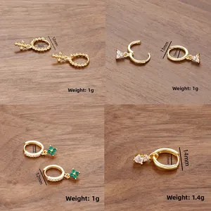 Detail view of 18k gold plated hoop earrings with cross and clover zircon charms