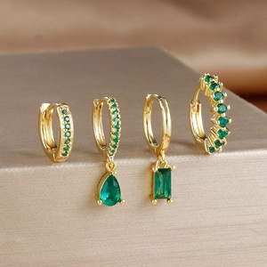 Detail of four-piece gold earring set with rectangular and pear-shaped green zircons