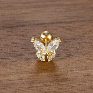 Primer plano de piercing de mariposa dorada con cristales de circón sobre fondo oscuro