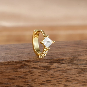 Macro shot of gold-plated hoop earrings with square zircon and fine crystal pavé