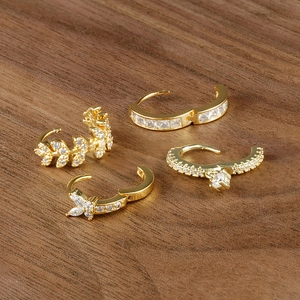 Elegant gold-plated copper huggie earrings with cubic zirconia in four distinct designs