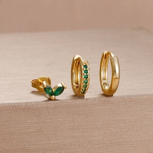 Detailed set of three gold earrings featuring green gemstones and a plain polished hoop