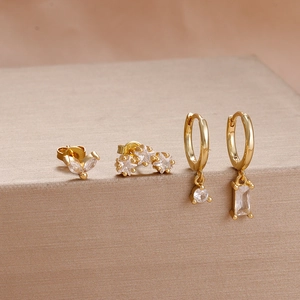 Λεπτομερής λήψη τεσσάρων χρυσών σκουλαρικιών με ζιργκόν σε σχήμα μαρκίζ και αστεριού