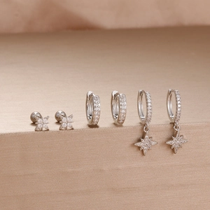 Detail shot of three pairs of silver zircon earrings including stars and hoop designs