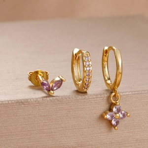 Macro detail of three-piece purple zircon stud earring set in polished gold finish