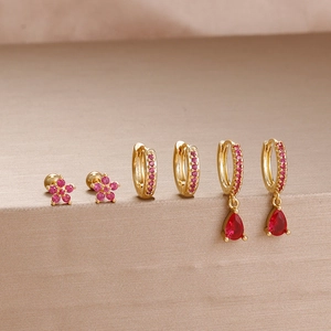 Close-up of gold stainless steel earrings set with pink and red zircon stones