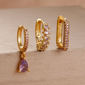 Detailed view of three gold-plated earrings set with elegant purple zircon stones