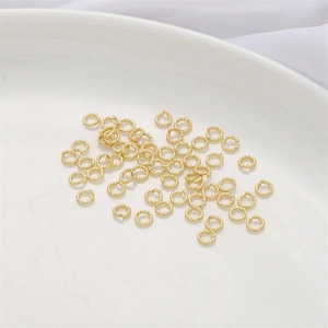 Détail des anneaux brisés torsadés plaqués or 14K sur une assiette en céramique