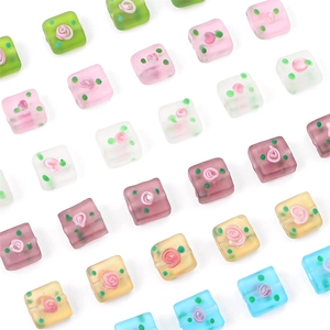 Detail of square frosted glass beads with pink rose motifs and colorful polka dots