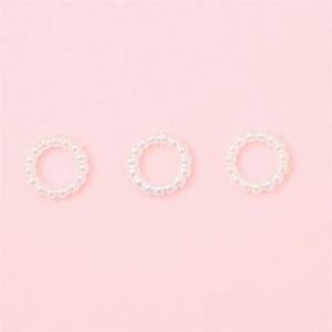 Nahaufnahme von drei weißen Perlen-Ringen für DIY-Schmuck und Ohrring-Zubehör