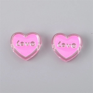 Detail view of pink transparent acrylic heart beads featuring embossed Love lettering