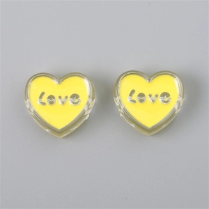 Close-up of yellow heart-shaped acrylic charms with silver Love inscription for DIY jewelry