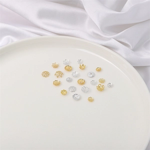 Copriperle assortiti in oro 14K e argento per creazione di gioielli su raso bianco