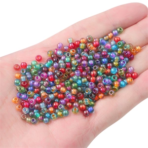 Multi-colored 4mm glass seed beads with rainbow core for DIY jewelry making in hand