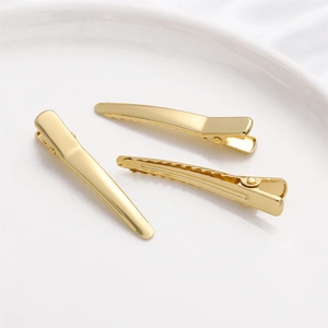 Detail von 14K vergoldeten Haarspangen mit gezackten Kanten auf einer Keramikplatte