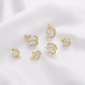 Close-up of 14K gold-plated opal pendants on white silk for jewelry making