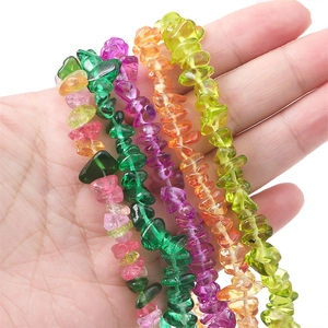 Bunte unregelmäßige Glastropfen für DIY-Schmuckherstellung in der Hand gehalten