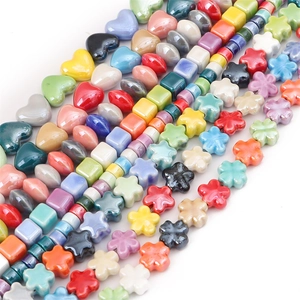 Detailed view of colorful glazed ceramic beads in heart, square, and flower shapes