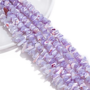 Detalle de cuentas irregulares de concha violeta natural para bisutería artesanal