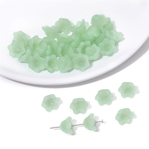 Macro shot of lily-of-the-valley glass beads with soft green gradient for DIY jewelry