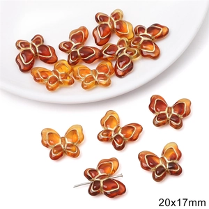 Macro detail of amber butterfly acrylic beads with gold edges for DIY jewelry 20x17mm