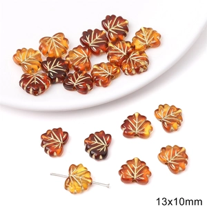 Macro detail of amber leaf-shaped acrylic beads with gold veins and 13x10mm sizing