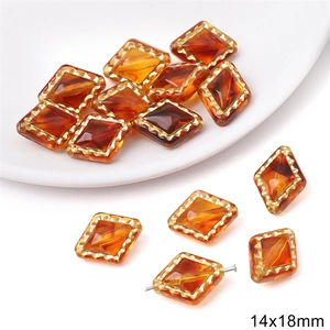 Detailed macro view of 14x18mm amber acrylic beads with decorative golden wavy borders