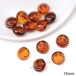 Macro shot of 15mm amber acrylic baroque beads with golden vintage pattern detail