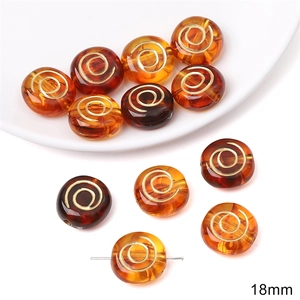 Detailed macro view of 18mm amber acrylic beads with golden spiral wire inlay for DIY