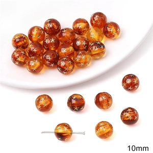 Detailed macro of 10mm amber acrylic beads with gold stars for DIY jewelry