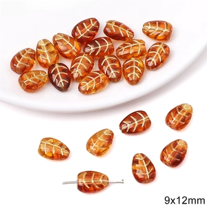 Macro shot of 9x12mm amber leaf beads with gold texture for DIY jewelry making