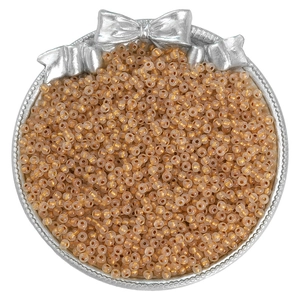Close-up of champagne mini glass seed beads in a silver tray for DIY jewelry making