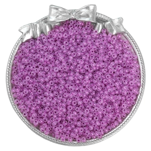 Detailed view of purple transparent seed beads in a silver tray for DIY jewelry making